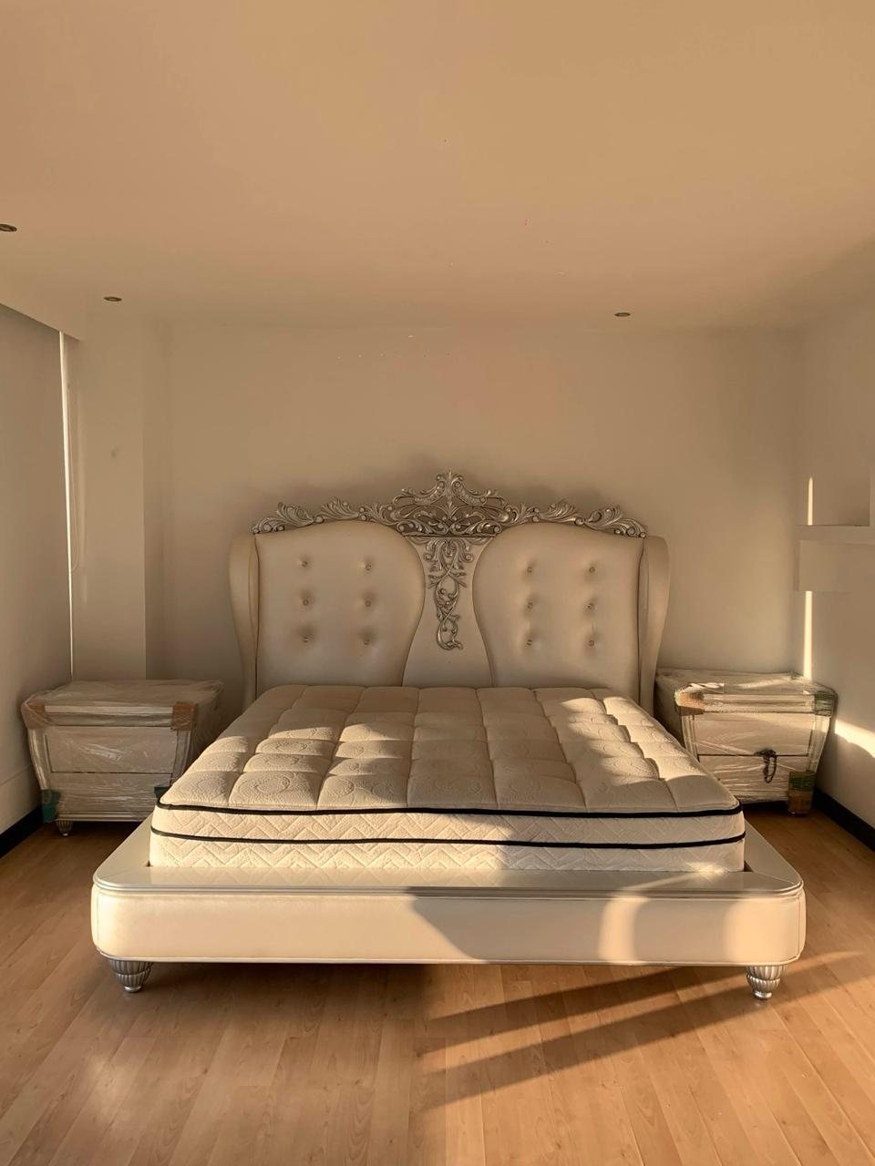 Dormitorio clásico con cama y mesas laterales