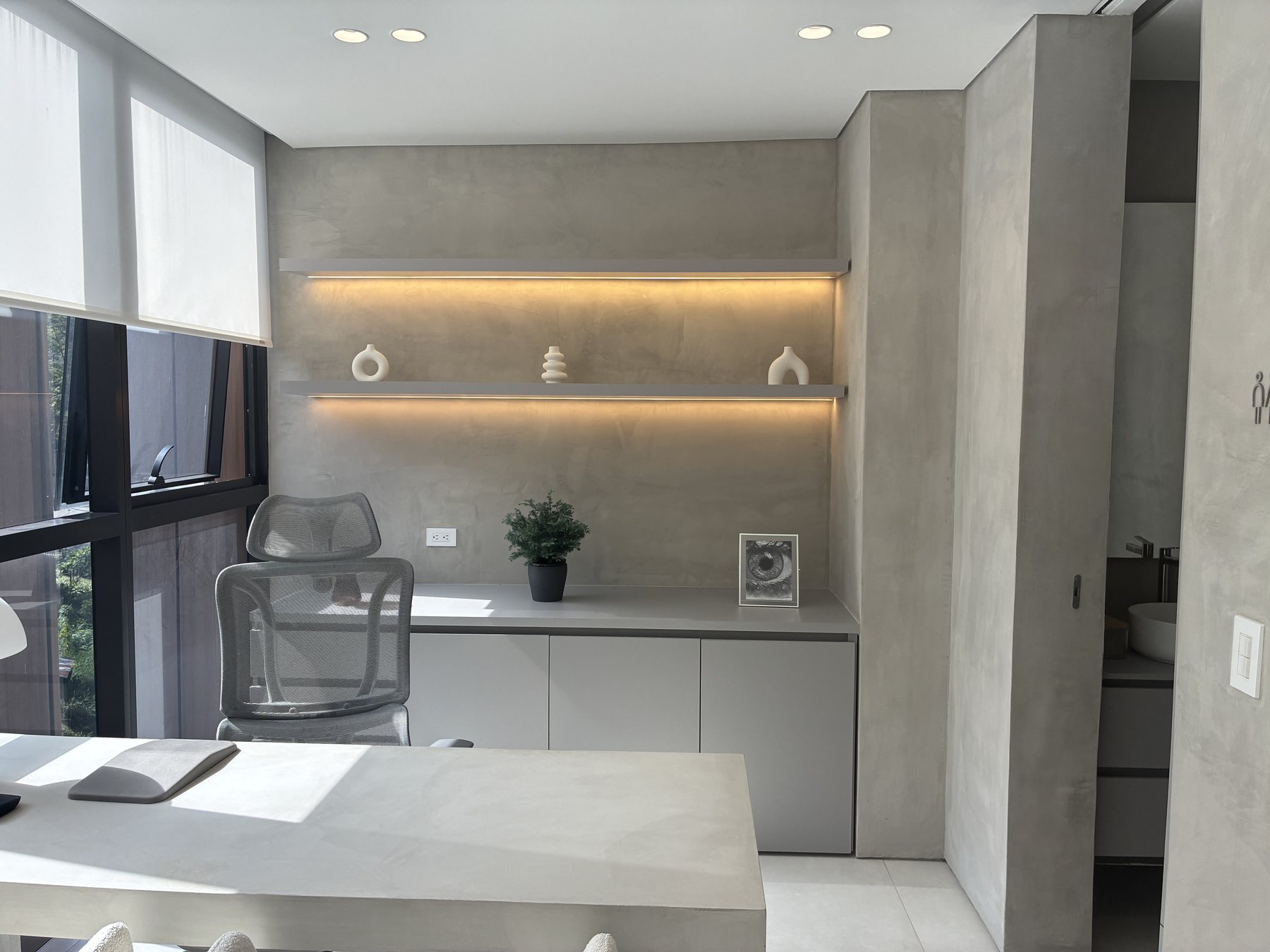 Adecuación interior con mobiliario gris e iluminación lineal